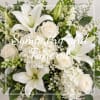 White lilies and roses in a sympathy bouquet with hydrangea
