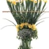 Tall arrangement of yellow daffodils in a clear glass vase