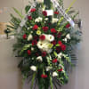 Standing funeral spray with red and white flowers on an easel
