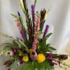 Tall mixed floral arrangement with calla lilies, orchids, and purple spikes