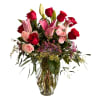 Bouquet of red roses and pink lilies in a clear glass vase