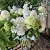 White and pale green bouquet in a clear glass vase
