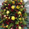 Large mixed floral spray with red, yellow, and peach blooms