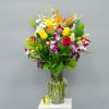 Mixed bouquet of roses, orchids, lilies, and bird of paradise in a glass vase