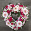 Heart-shaped floral wreath with pink, white, and red blooms