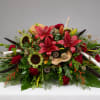 Large floral arrangement with red lilies, sunflowers, and red carnations