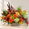 Autumn floral arrangement in a woven basket with orange and red blooms