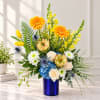 Bright mixed bouquet in a blue vase with yellow, white, and blue flowers