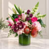 Mixed bouquet of pink, white, and purple flowers in a glass vase