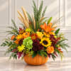 Fall floral arrangement in a pumpkin container with sunflowers and lilies