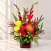 Tropical bouquet with red and yellow flowers in a red glass vase