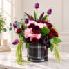 Bouquet of purple tulips, roses, and pink blooms in a plaid hatbox