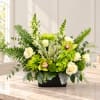 Green and white floral arrangement in a black rectangular vase