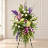 Tall standing floral spray with white roses, purple orchids, and green foliage