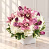 Pink orchids and roses arranged in a white square vase