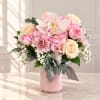 Pink and cream bouquet in a pink vase with a ribbon
