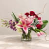 Pink lilies and red roses in a clear glass vase