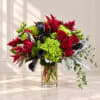 Bouquet of red roses, green hydrangea, and dark calla lilies in a glass vase.