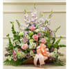 Basket arrangement of pink roses, daisies, and tall lavender flowers with a peach ribbon