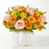Peach roses and yellow-orange mums in a white pumpkin vase
