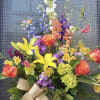 Colorful bouquet with yellow lilies, orange roses, and purple flowers