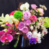 Mixed bouquet of pink, purple, white, and green flowers in a vase
