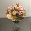 Pastel bouquet of roses and mixed blooms in a clear glass vase