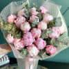 Bouquet of pink peonies with eucalyptus in striped wrapping