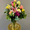 Mixed bouquet of roses and lilies in a gold vase