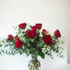 Red roses arranged in a clear glass vase