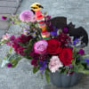 Colorful bouquet with roses, carnations, and a candy topper in a vase