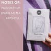 Hand holding a scented sachet package beside a pink note card
