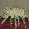 White floral casket spray with lilies and roses