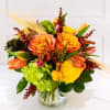Orange and yellow floral arrangement in a clear glass vase