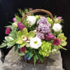 Mixed flower basket with purple, white, and green blooms