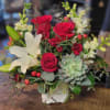 Bouquet of red roses and white lilies with a succulent in a white vase