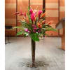 Tall tropical floral arrangement in a floor vase with pink and orange blooms