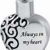 Heart-shaped silver pendant with black swirl design and text