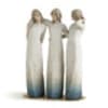 Three blurred figures in long white dresses standing together