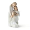 Three faceless figurines in white dresses posed closely together