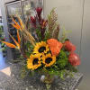 Tropical bouquet with sunflowers, orange roses, and bird of paradise in a vase