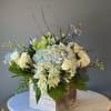 White and pale blue floral arrangement in a wooden box