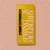 Box of pecan date chocolate on a pink textured surface