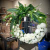 Large white floral wreath on an easel with green foliage and tulips