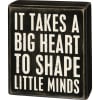 A classic black and white wooden box sign featuring a distressed "It