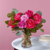 Pink roses and carnations in a clear glass vase