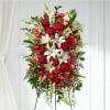 Standing spray of red roses and white lilies on an easel