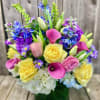 Colorful bouquet with yellow roses, pink calla lilies, and blue-purple flowers in a vase
