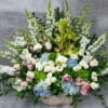 Large basket arrangement with white and pastel flowers and tall green spikes