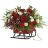 flowers in a red sleigh bouquet  container might change based on